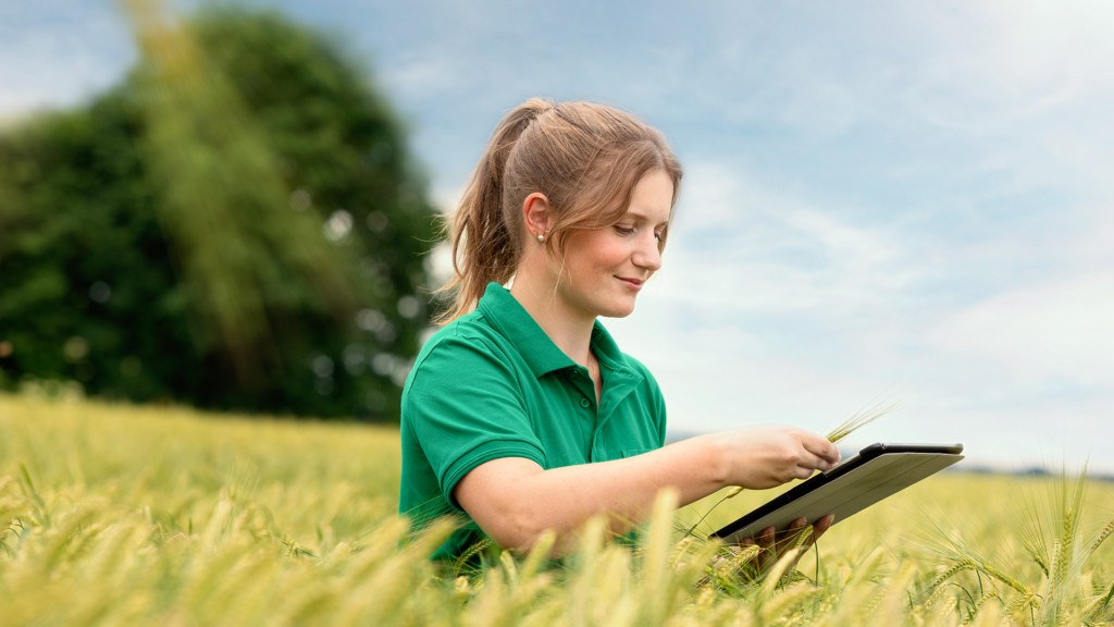 Martina überprüft als Pflanzenbauberaterin bei Dehner Agrar mit Hilfe eines Tablets das Getreide auf dem Feld