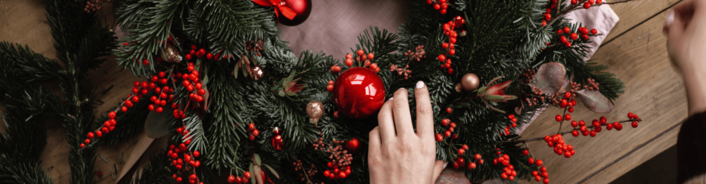 Adventskranz mit roten Akzenten wird gebunden