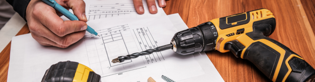 Zeichenskizze und Akkuschrauber auf einem Holztisch