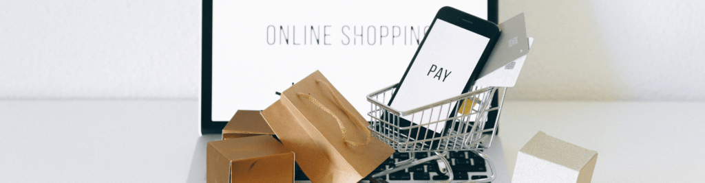 Online-Shopping am Laptop und Bezahlung per Smartphone