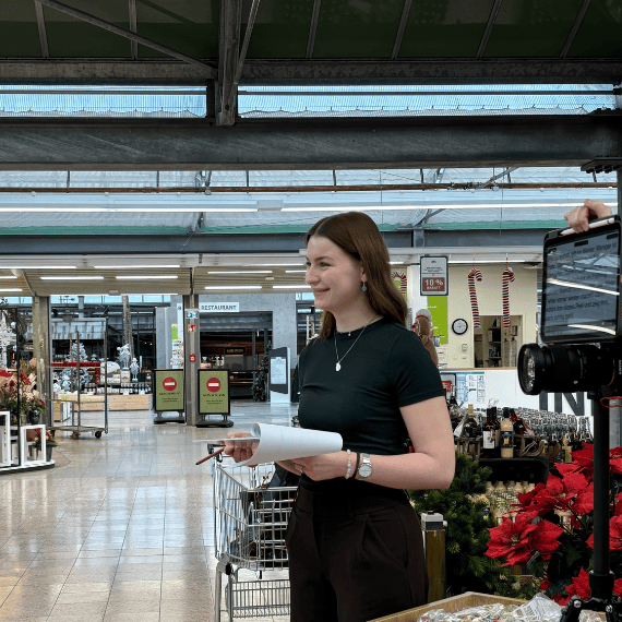 Eine Frau im schwarzen Shirt steht an einem Filmset