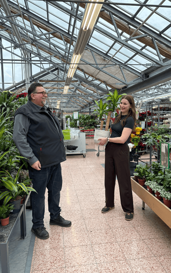 Ein Mann und eine Frau sind Darsteller bei einem Videodreh im Garten-Center
