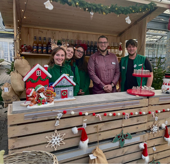 Fünf Personen in einer weihnachtlichen Holzhütte