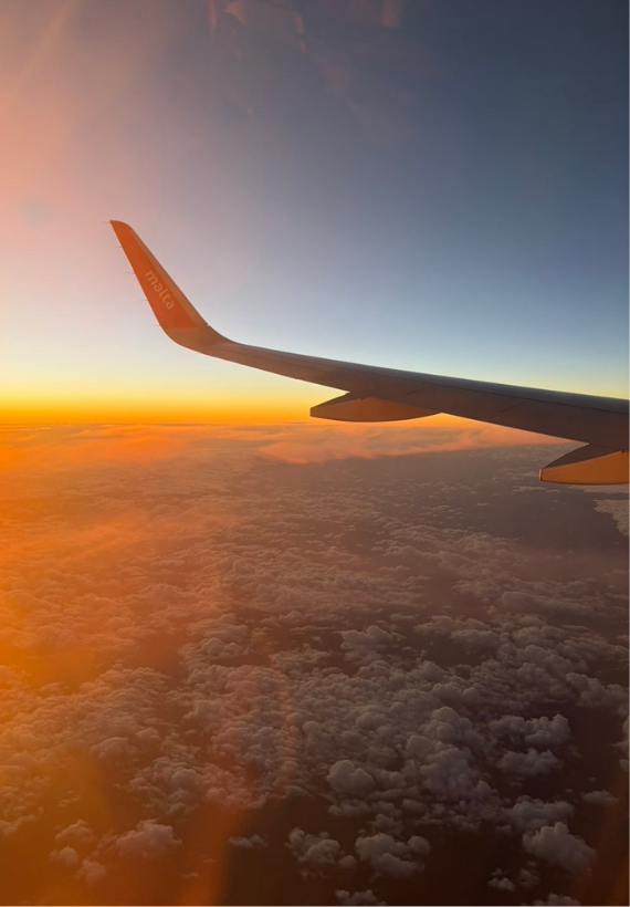 Flugzeugerflüger bei Sonnenuntergang über den Wolken