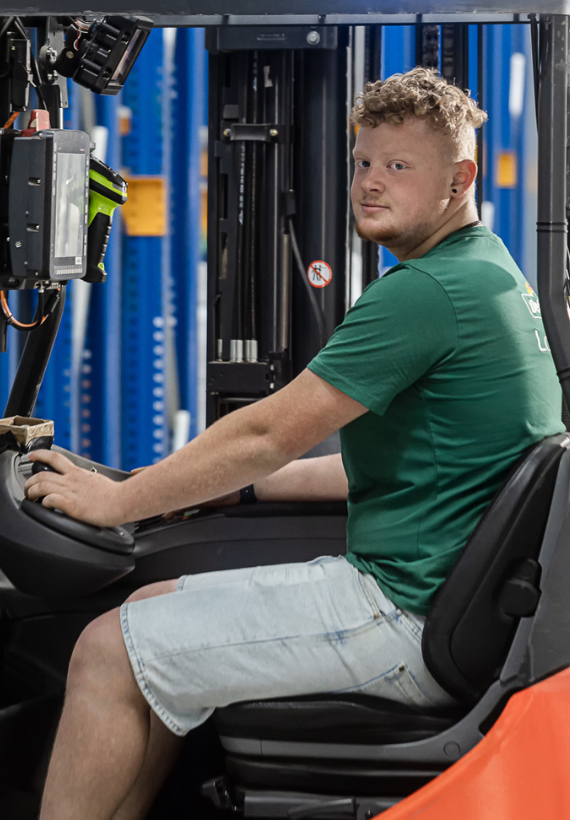 Auszubildender sitz im Gabelstabler und bedient diesen