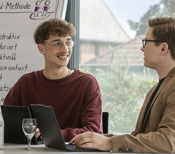 zwei Männer am Laptop im Büro