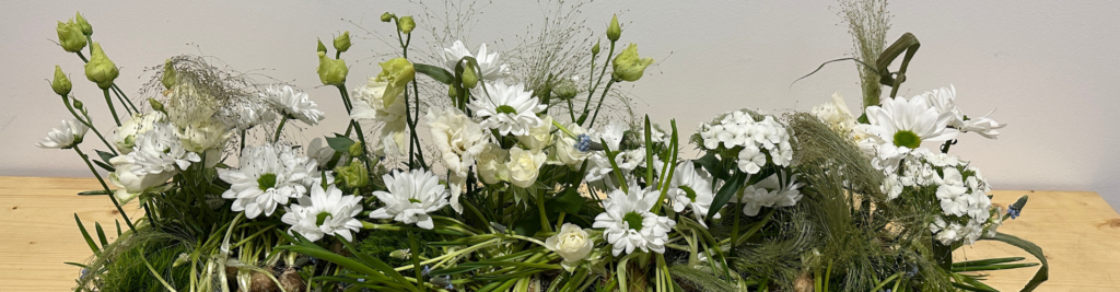 Blumengesteck mit Gräsern und weißen Blumen