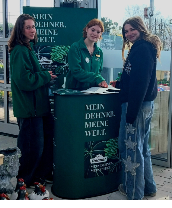 Drei Lehrling hinter einem Dehner-Stand