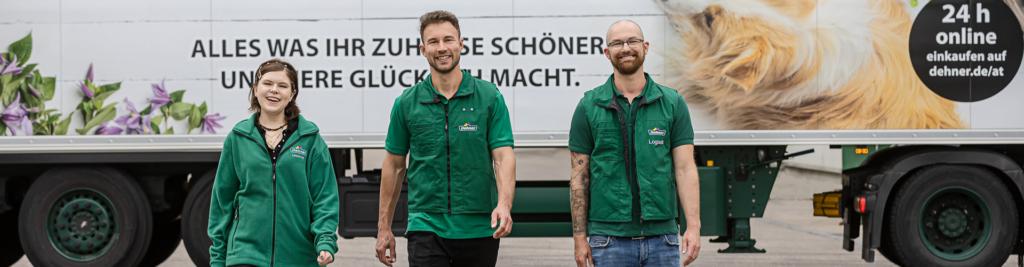 Eine Mitarbeiterin und zwei Kollegen in grüner Arbeitskleidung laufen vor einem Dehner LKW
