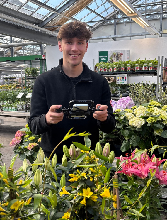 Junger Mann filmt mit dem Handy in einem Stativ