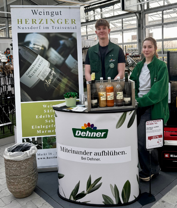 Zwei Lehrlinge hinter einem Verköstigungsstand für Säfte