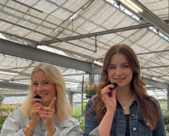Zwei Frauen mit einem Mikrophon stehen vor der Kamera und drehen ein Reel