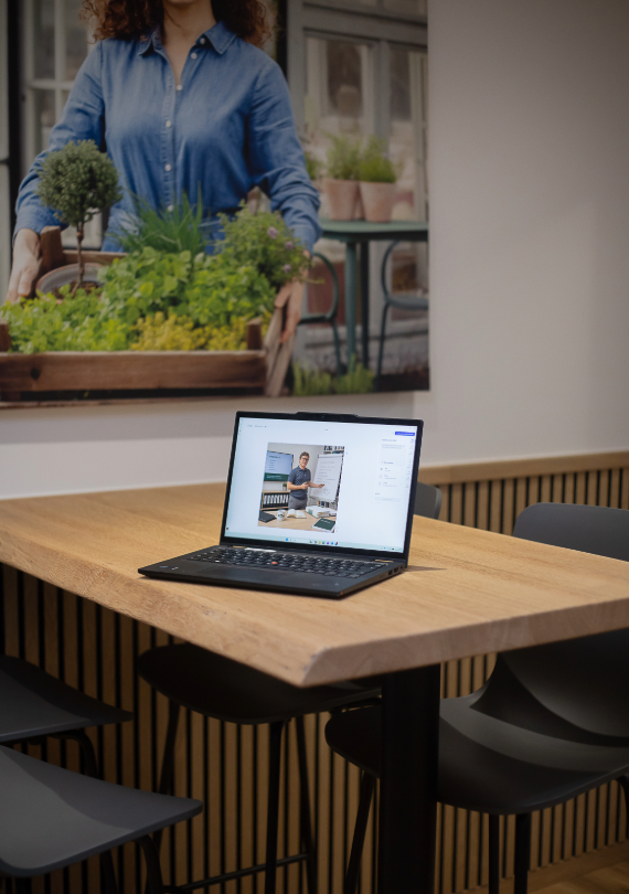 Laptop mit virtueller Präsentation auf einem Besprechungstisch in modernem Unternehmensbüro